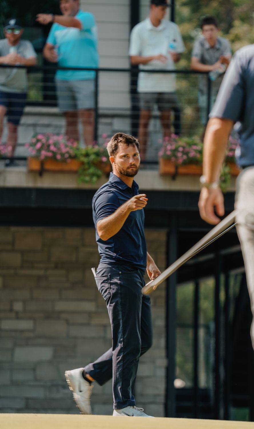 Zander pointing toward a playing partner after holing a putt
